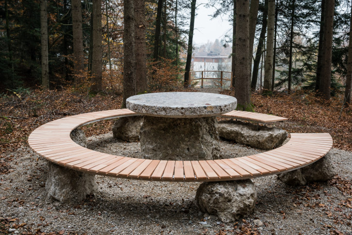 Rund um den vom Adneter Steinmetz Berthold Ziller errichteten Steintisch lädt eine Sitzbank aus Lärchenholz zum Entspannen und Meditieren ein.